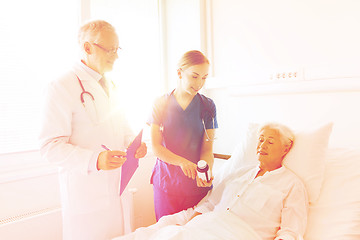 Image showing doctor giving medicine to senior woman at hospital