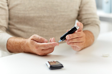 Image showing close up of old man with glucometer blood test