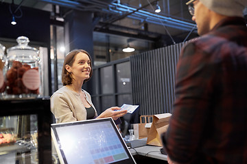 Image showing happy woman paying money to seller at cafe