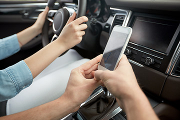 Image showing happy man and woman with smartphone driving in car