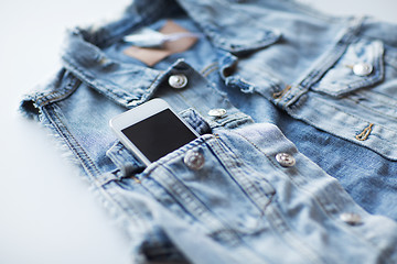 Image showing smartphone in pocket of denim jacket or waistcoat