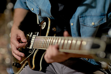 Image showing close up of man playing guitar at studio rehearsal