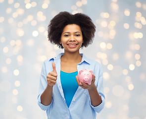 Image showing happy woman with piggy bank showing thumbs up