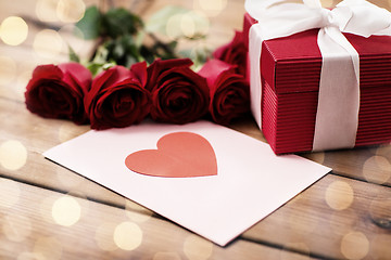 Image showing close up of gift box, red roses and greeting card