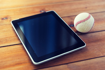 Image showing close up of baseball ball and tablet pc on wood