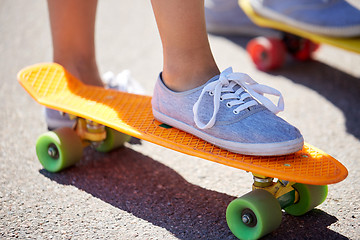 Image showing close up of female feet riding short skateboard