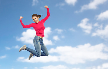 Image showing smiling young woman jumping in air