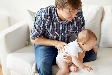 Image showing happy young father with little baby at home