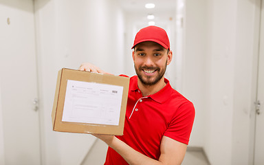 Image showing delivery man with parcel box in corridor