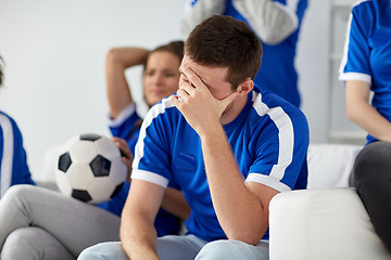 Image showing unhappy man with friends or football fans at home