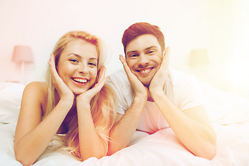 Image showing happy couple lying in bed at home