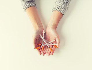 Image showing close up of woman hands holding syringes