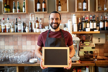 Image showing happy man or waiter with chalkboard banner at bar
