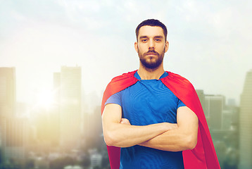 Image showing man in red superhero cape over city background