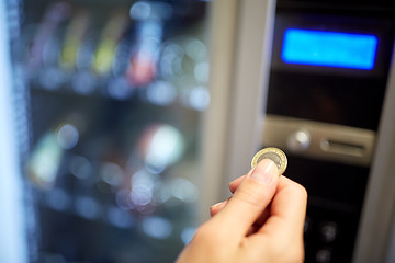 Image showing hand inserting euro coin to vending machine slot