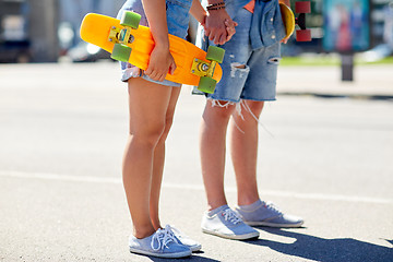 Image showing close up of young couple with skateboards in city