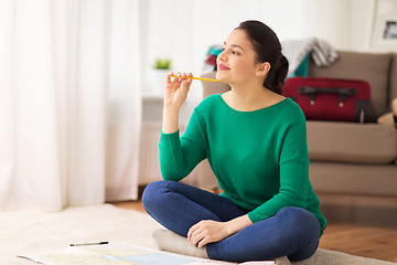 Image showing happy young woman with travel map at home