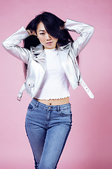 Image showing young pretty smiling asian korean girl wearing modern fashion clothers on pink background, lifestyle people concept 