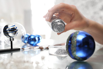 Image showing Woman decorate baubles. Christmas tree decorations