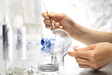 Image showing Woman decorate baubles. Christmas tree decorations