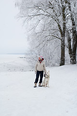 Image showing Woman walking with a dog in winter