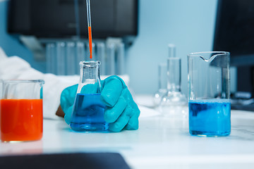 Image showing Laboratorian with flask on table