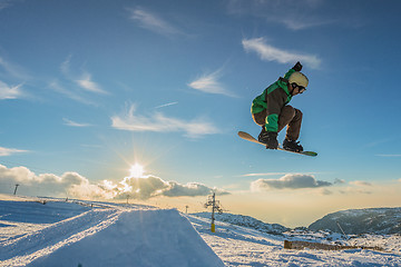 Image showing Snowboarder jumping against blue sky