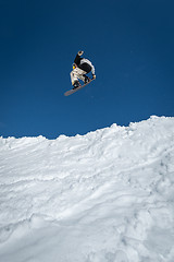 Image showing Snowboarder jumping against blue sky