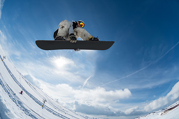 Image showing Snowboarder jumping against blue sky