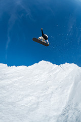 Image showing Snowboarder jumping against blue sky