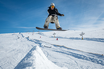 Image showing Snowboarder jumping against blue sky