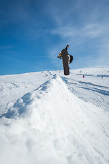 Image showing Snowboarder jumping against blue sky