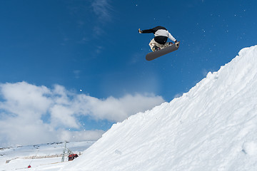 Image showing Snowboarder jumping against blue sky