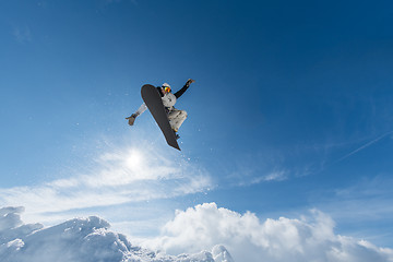 Image showing Snowboarder jumping against blue sky