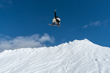 Image showing Snowboarder jumping against blue sky