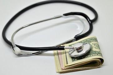 Image showing Stethoscope sitting on US dollar bills