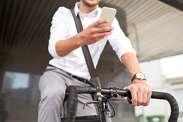 Image showing man with smartphone and fixed gear bike on street