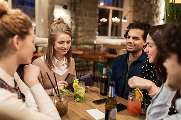 Image showing friends with drinks, credit card and bill at bar