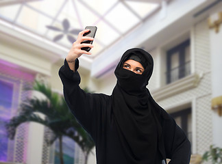 Image showing muslim woman in hijab taking selfie by smartphone