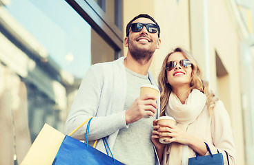 Image showing happy couple with shopping bags and coffee in city