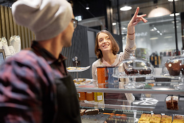 Image showing happy woman showing something to bartender at cafe