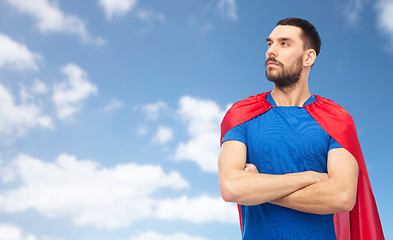 Image showing man in red superhero cape over blue sky