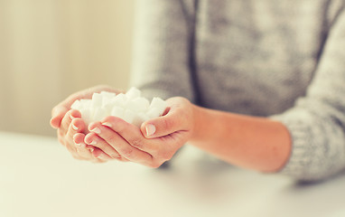 Image showing close up of white lump sugar in woman hands