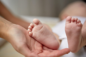 Image showing close up of newborn baby feet in mother hands