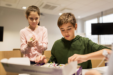 Image showing happy children building robots at robotics school