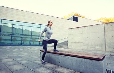 Image showing woman exercising on bench outdoors