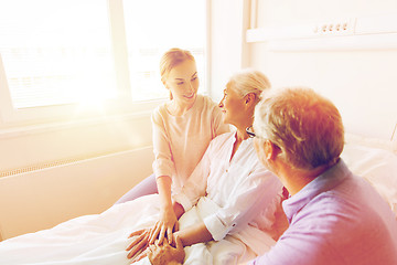 Image showing happy family visiting senior woman at hospital