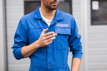 Image showing close up of auto mechanic smoking cigarette