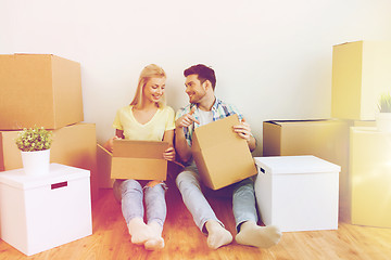 Image showing smiling couple with many boxes moving to new home