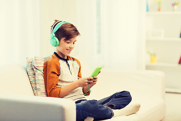 Image showing happy boy with smartphone and headphones at home